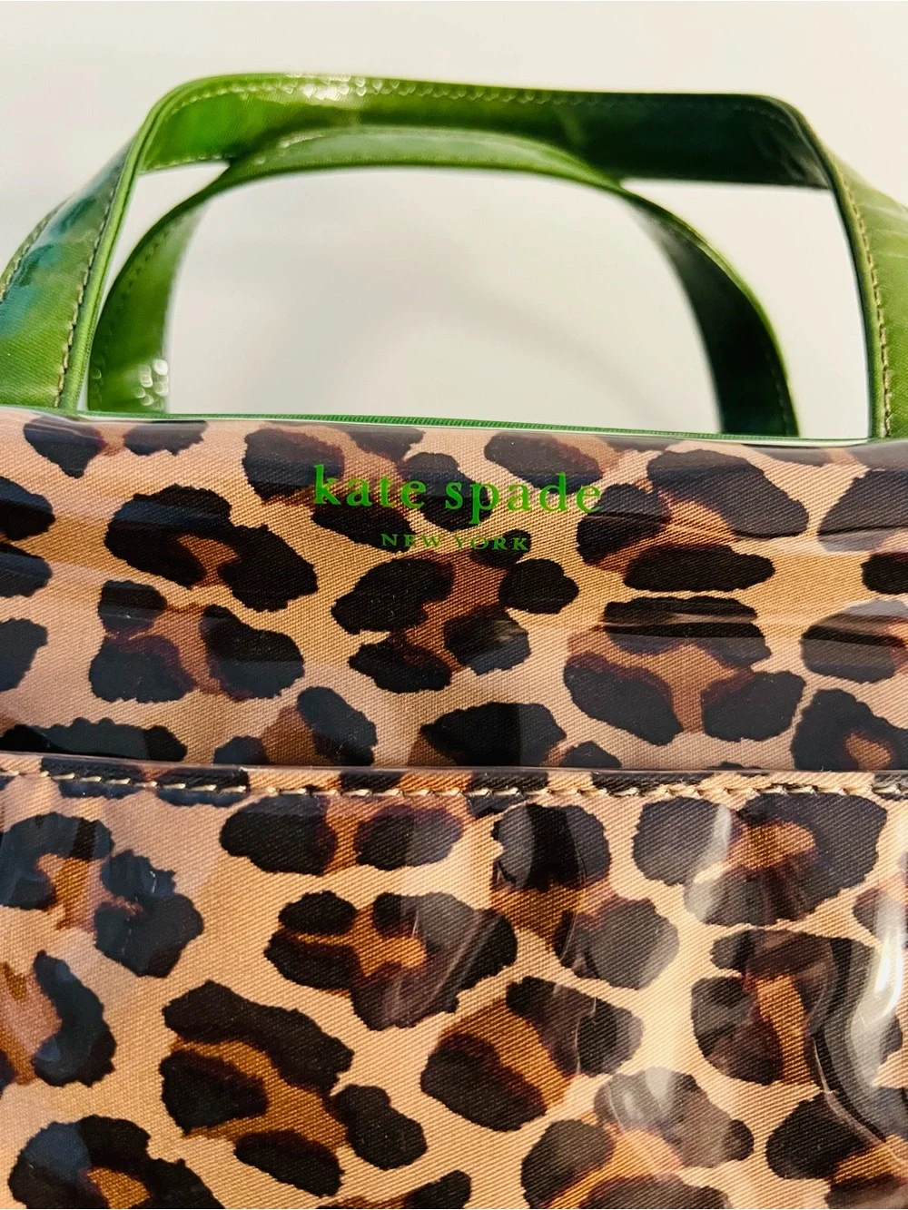 Brand new. Large Kate Spade cosmetic bag. Leopard print with green lining/trim.